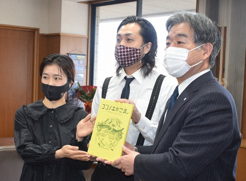 九重町の生物多様性を描いた絵本「ココノエのこえ」を持つ左から吉岡さん、阿部さん、日野町長