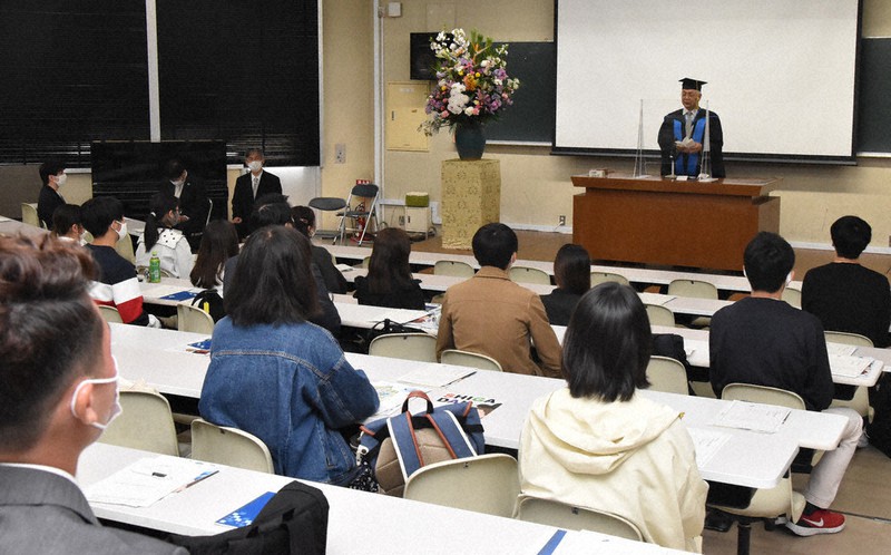 1年越しの入学式で、位田隆一学長の話を真剣に聞く新2年生=大津市平津2の滋賀大大津キャンパスで、菅健吾撮影