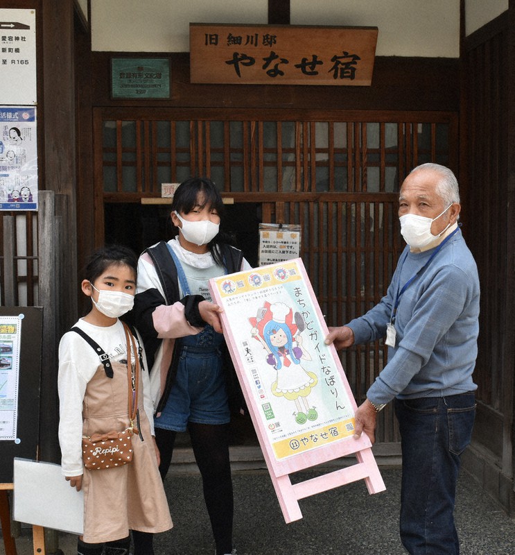 「なばりん」の立て看板設置を依頼する遠藤果歩さん(左)と浪花千早さん(中央)=名張市新町の旧細川邸やなせ宿で、行方一男撮影