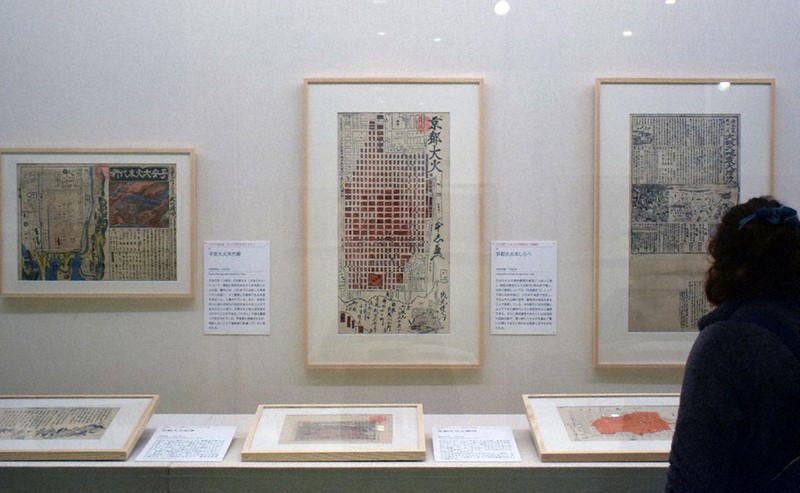 第1章「京都・大坂の災害史」で展示の焼失範囲を朱で示した絵図。大火ごとに出版され、速報から「本しらべ」をうたうものまで見られる=京都市中京区で、南陽子撮影