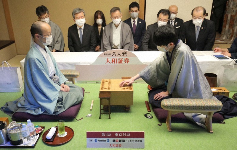 第79期名人戦七番勝負第1局で初手を指す挑戦者の斎藤慎太郎八段(右)。左は渡辺明名人=東京都文京区のホテル椿山荘東京で2021年4月7日、宮武祐希撮影