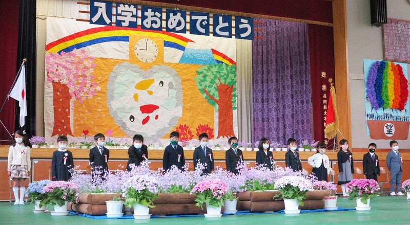 初狩小の入学式で、サクラソウに囲まれ、在校生らによる校歌を聞く新1年生=山梨県大月市で2021年4月6日、山本悟撮影