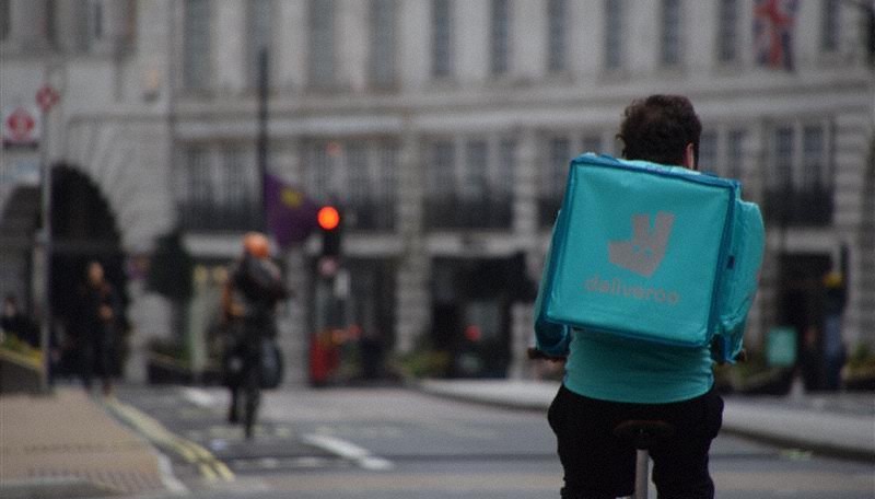英国の街中を自転車で走るデリバルーの配達員=ロンドンで2021年4月1日、横山三加子撮影