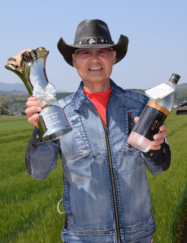 トロフィーと「赤尾」を手にする宮本さん