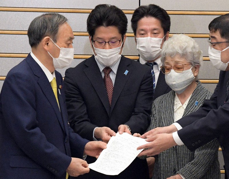 菅義偉首相(左端)に「家族会・救う会 今後の運動方針」を手渡す横田早紀江さん(右から2人目)ら=首相官邸で2021年4月7日午後3時10分、竹内幹撮影