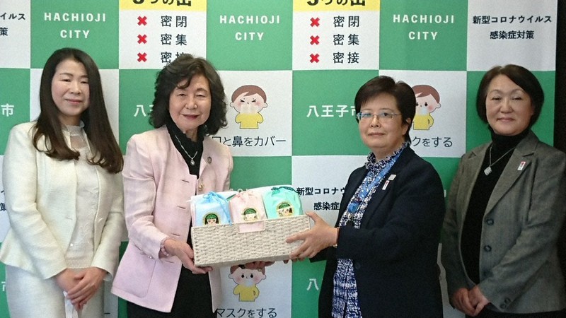 生理用品を寄付し、木内基容子副市長(右から2人目)に手渡すシルクレイズ名誉会長の町田典子さん=八王子市役所で2021年3月26日、野倉恵撮影