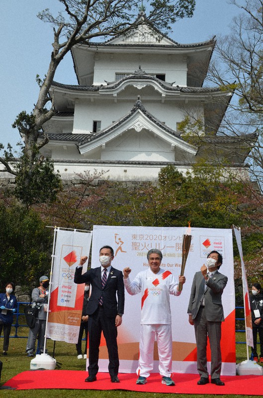 伊賀上野城前の出発式で聖火のトーチを持つ鳥羽一郎さん(中央)と鈴木英敬知事(左)、岡本栄・伊賀市長=三重県伊賀市上野丸之内で2021年4月8日午前9時25分、大西康裕撮影
