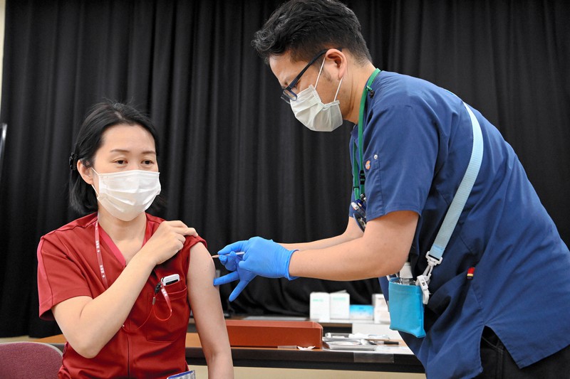 新型コロナウイルスワクチンの接種を受ける看護師(左)=大阪市住吉区の大阪急性期・総合医療センターで2021年3月8日午後1時35分(代表撮影)