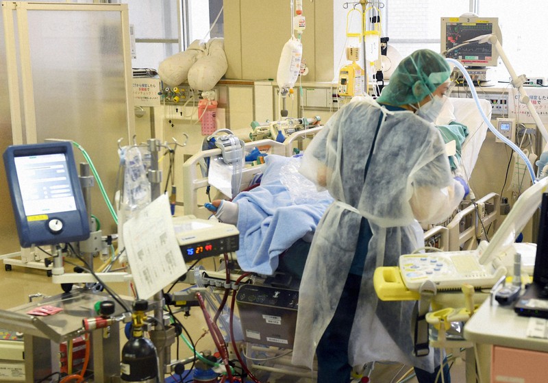 重症者の治療に使われる人工心肺装置「ECMO(エクモ)」が稼働する病室で患者のケアにあたる看護師=福岡市城南区の福岡大病院で2020年12月24日、矢頭智剛撮影