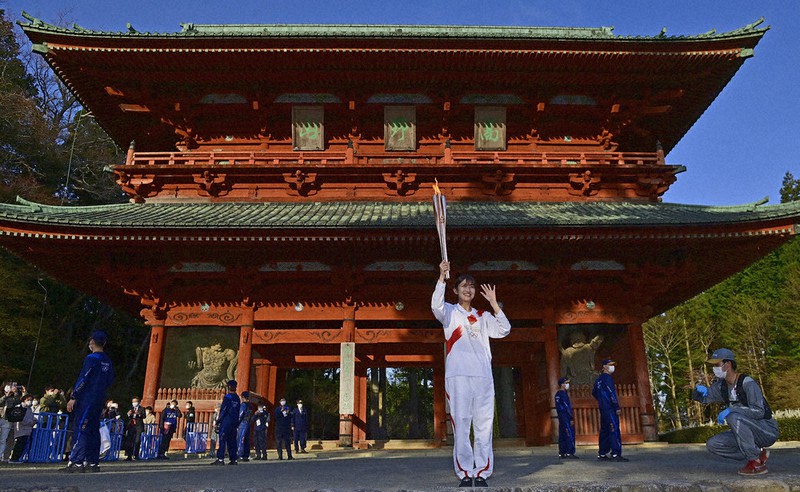 第5区間のゴール・金剛峯寺大門に到着した聖火ランナーの竹川智世さん=和歌山県高野町で2021年4月10日午後5時14分、藤井達也撮影