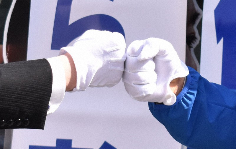 握手の代わりに交わすグータッチ=長野市内で2021年4月8日午前9時22分、坂根真理撮影