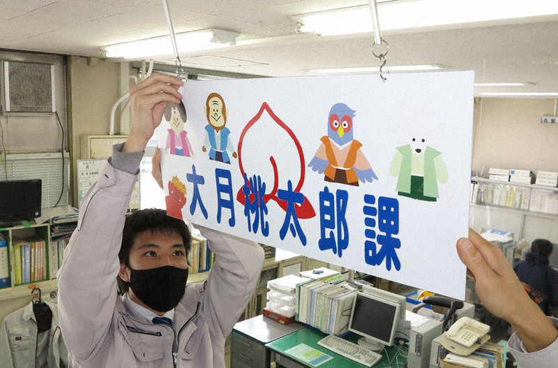 天井に吊り下げられた課の案内看板を付け替える職員=山梨県大月市内で2021年4月1日、山本悟撮影