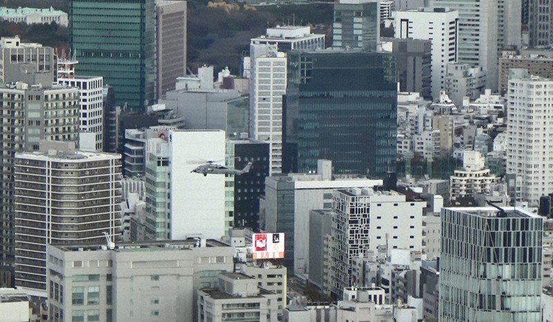 東京・山手線内の市街地を低空で旋回した後、ショッピング街が広がる表参道(渋谷、港区)周辺を北西に向けて飛ぶ米海軍ヘリ「シーホーク」。住民からは防衛省に苦情があり、取材班が撮影した機体とほぼ一致している=都内で2020年12月、大場弘行撮影(写真は動画から)