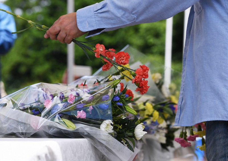 入所者19人が殺害された事件から4年を迎えた津久井やまゆり園に設けられた献花台に花を供える人=相模原市緑区で2020年7月、滝川大貴撮影