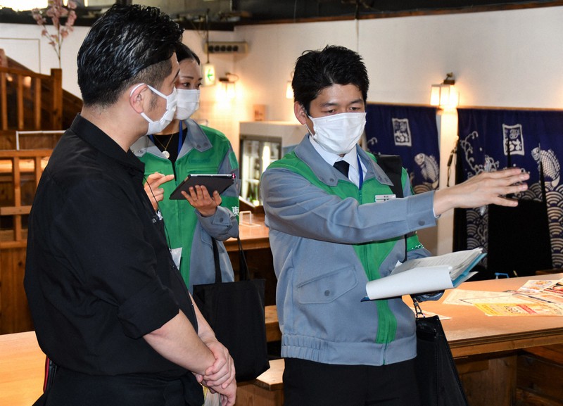 距離を保った席の配置について店長(左)に助言する東京都の職員=新宿区の「釣船茶屋ざうお新宿店」で2021年4月12日午後2時12分、黒川晋史撮影