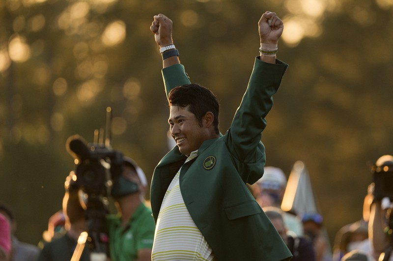 黄色いシャツにグリーンジャケットを羽織って喜ぶ松山英樹=米ジョージア州オーガスタで2021年4月11日、AP