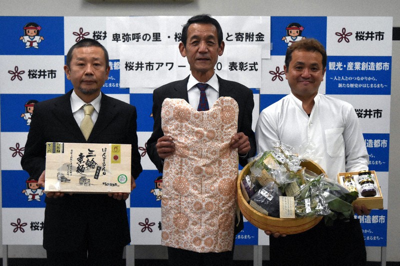 「桜井市アワード2020」を受賞し、表彰式に参加した「井上ふとん店」の井上佳輝さん(中央)ら3業者=奈良県桜井市役所で、広瀬晃子撮影