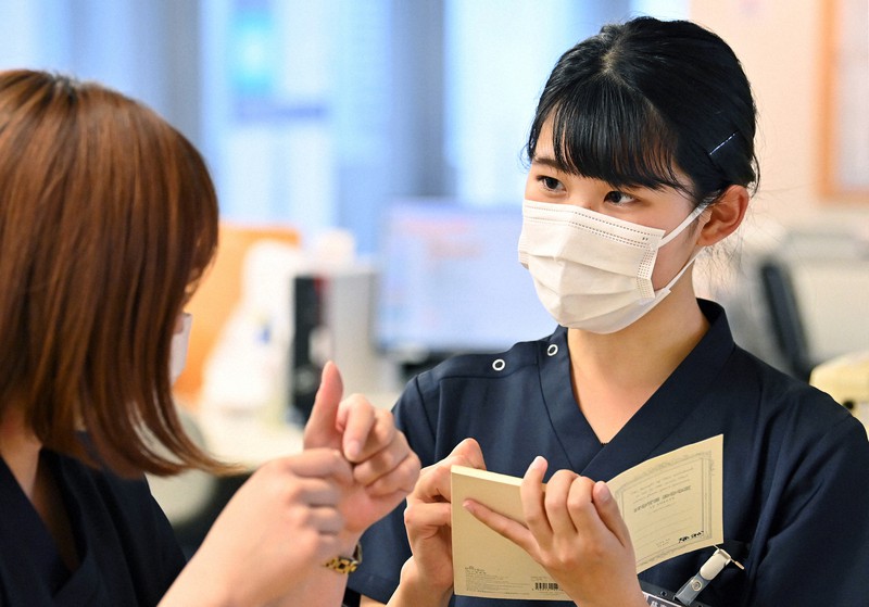 先輩からの教えを真剣な表情で書きとめる大西美香さん(右)=東京都港区で2021年4月8日、大西岳彦撮影