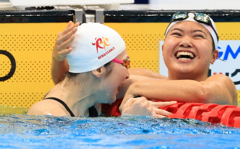 女子100メートルバタフライ決勝を制し、2位の長谷川涼香にたたえられ涙を流す池江璃花子(左)=東京アクアティクスセンターで2021年4月4日、梅村直承撮影