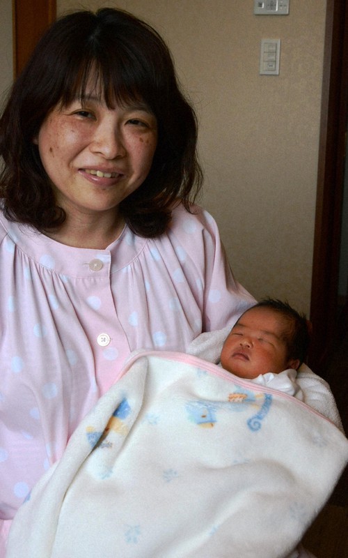 本震の約1時間前に生まれた飯田京華ちゃんを抱く母あずささん=熊本市中央区で2016年4月20日、柿崎誠撮影