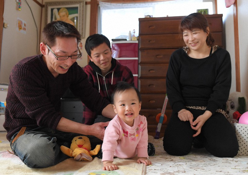 飯田京華ちゃん(中央)を中心に家族は笑顔に包まれた=熊本市中央区で2017年3月26日、須賀川理撮影