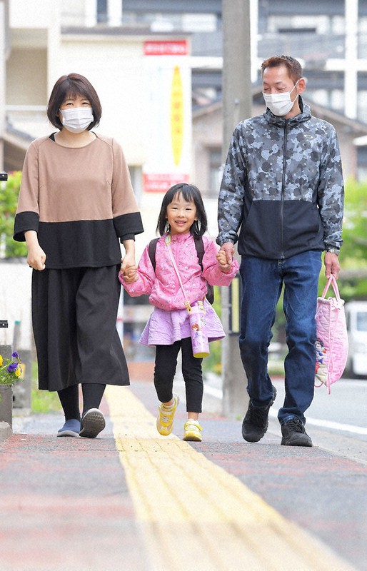 父児郎さん、母あずささんと手をつなぎ、元気に登園する飯田京華ちゃん(中央)=熊本市中央区で2021年4月12日午前7時44分、津村豊和撮影