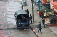 Police security forces stand by inside a police vehicle and on the sidewalk of Hledan Road in Kamayut township in Yangon, Myanmar on April 16, 2021. (AP Photo)