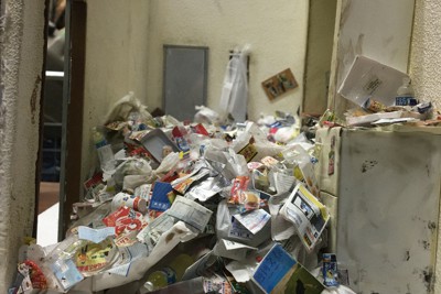 何層にもごみが重なった「ごみ屋敷」。玄関ドアも開きづらい状態に。居住者は真面目な性格の人が多いという＝東京都板橋区で2021年4月6日午後4時10分、生野由佳撮影