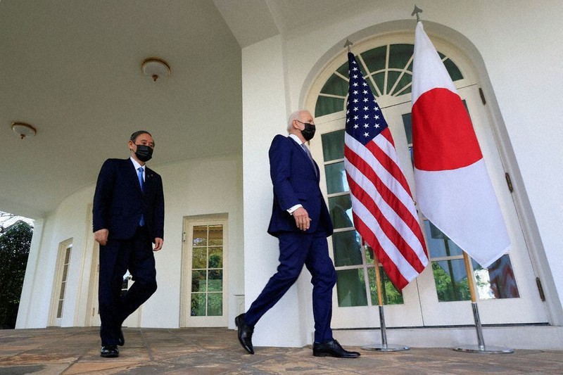 米大統領執務室を出て共同記者会見場に向かうバイデン大統領(右)と菅首相=米ワシントンのホワイトハウスで16日、ロイター