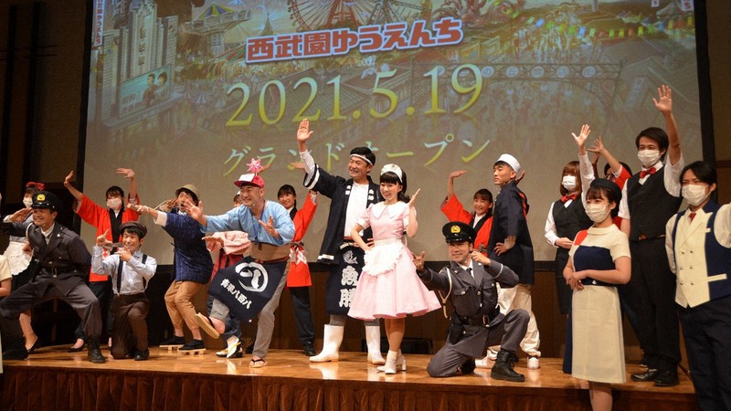 1960年代をイメージした町並みを再現する「商店街エリア」の住人ら(スタッフ)は来場者を巻き込むパフォーマンスを行う=2021年4月13日、田中学撮影