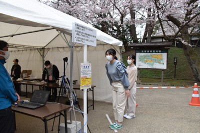 入り口で検温する来場者＝青森県弘前市下白銀町の弘前公園で２０２１年４月１７日、江沢雄志撮影