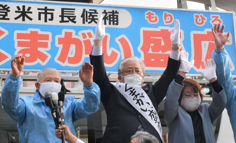 当選が決まり、万歳して喜ぶ熊谷盛広氏(中央)=宮城県登米市迫町で2021年4月18日午後5時12分、藤田花撮影