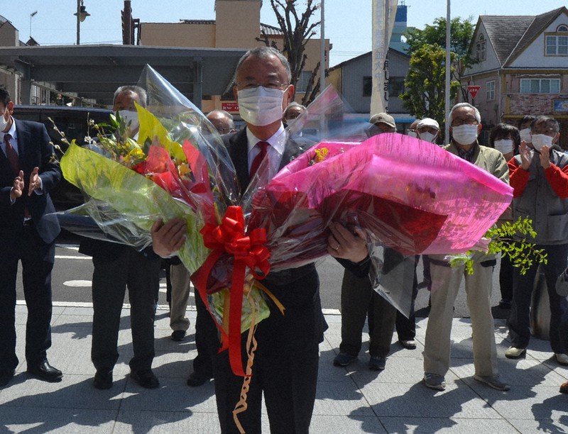 支持者らから贈られた花束を手に登庁する金子市長=栃木県佐野市で2021年4月19日、太田穣撮影