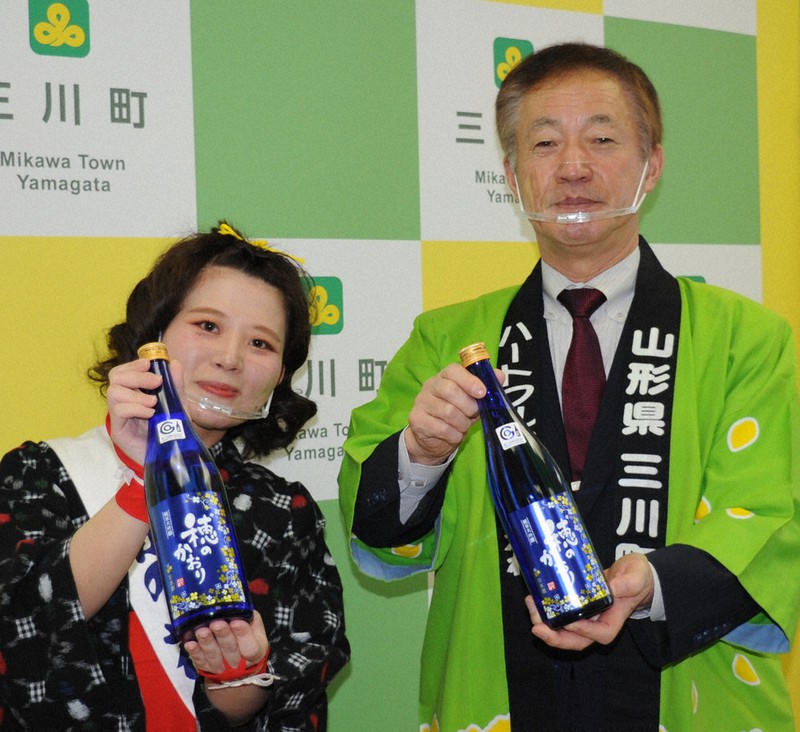 完成した酒をPRする阿部誠町長(右)ら=山形県三川町役場で2021年4月16日、長南里香撮影