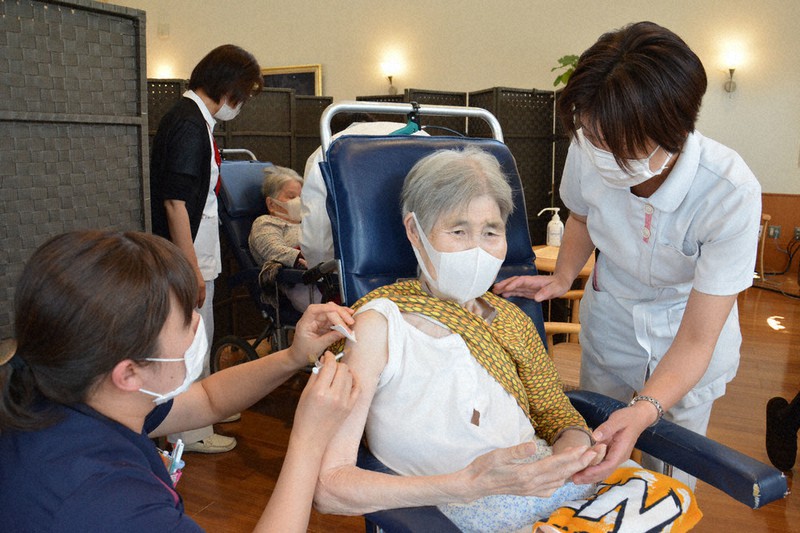 ワクチンの接種を受ける高齢者入所施設の女性(中央)=三重県名張市で、名張市提供