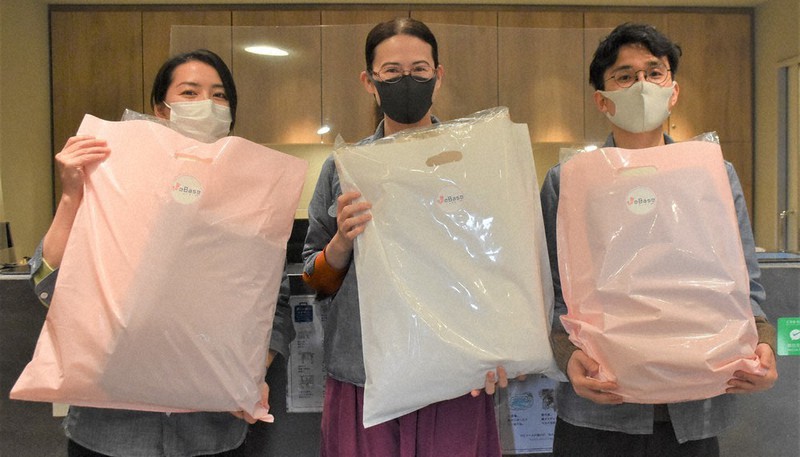 経済的に困窮する子育て世帯に提供した枕を手にする「WeBase京都」の蓑部亜季子支配人(中央)とスタッフ=京都市下京区で2020年12月23日午後2時49分、添島香苗撮影