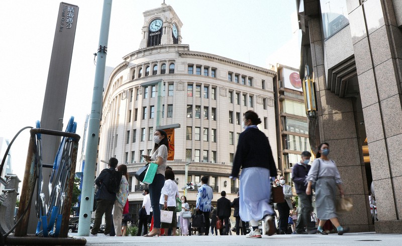 百貨店など多くの商業施設が並ぶ銀座4丁目交差点付近を行き交う人たち。緊急事態宣言の再発令で個人消費の落ち込みは避けられそうにない=東京・銀座で21日午後4時、小出洋平撮影