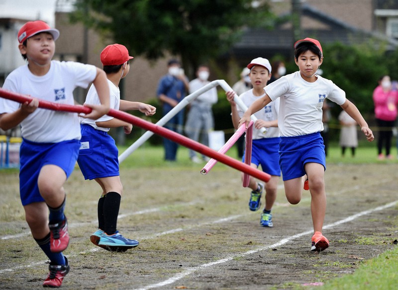運動会でソーシャルディスタンスを意識し長さ2メートルのバトンを使うリレーに臨む児童たち。コロナ下では運動機会の減少が懸念されている=相模原市の市立田名北小で2020年9月27日午前11時11分、滝川大貴撮影