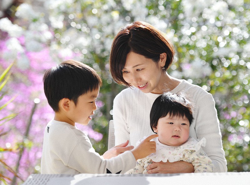 長女詩生ちゃんを抱いて、長男汰緯ちゃんと話す浅野千通子さん=兵庫県宝塚市で2021年3月31日、北村隆夫撮影