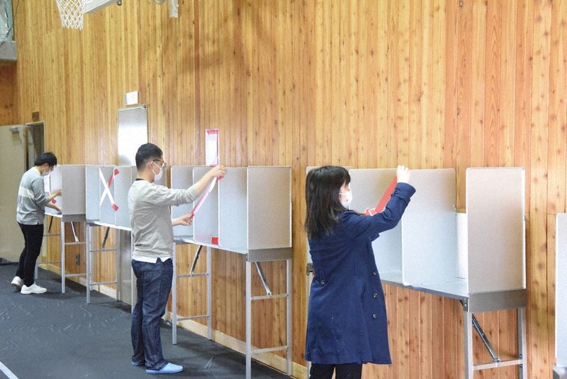 投票所の設営をする県立大生ら。投票記載台の中央のスペースは新型コロナ対策で利用不可にされた=長野市南長野の後町ホールで2021年4月24日、鈴木英世撮影