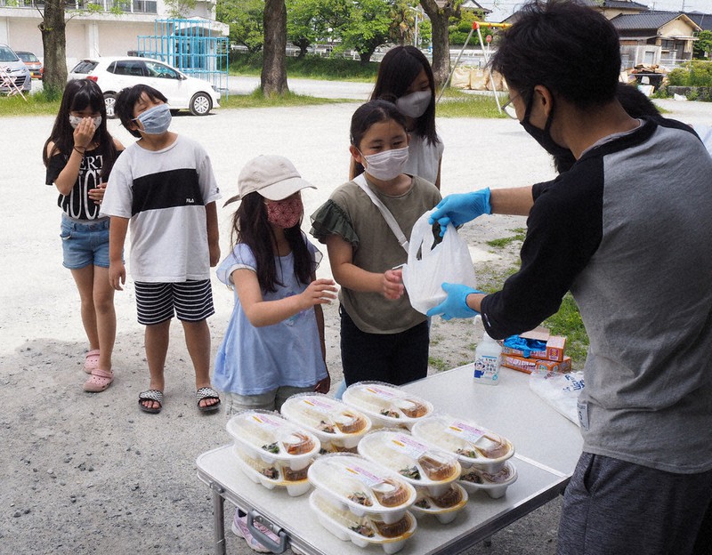 カレー弁当を並んで受け取る子供たち