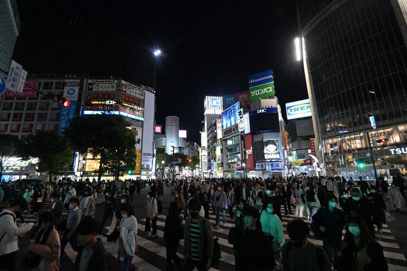 東京都の依頼により照明が減り、通常より暗くなった渋谷スクランブル交差点周辺。中央奥は「渋谷109」ビル=東京都渋谷区で25日午後8時1分、大西岳彦撮影