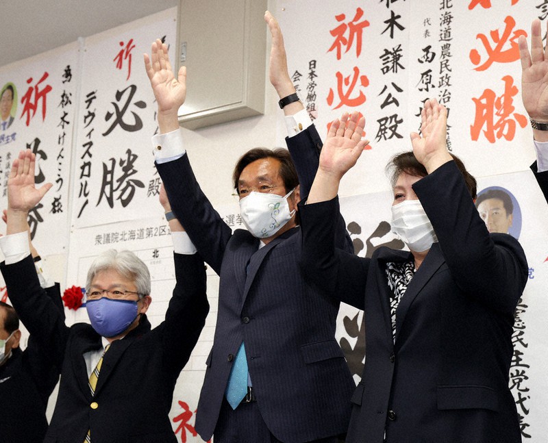 衆院北海道2区補選で当選が確実となり、万歳する松木謙公氏(中央)=札幌市北区で2021年4月25日午後8時13分、貝塚太一撮影