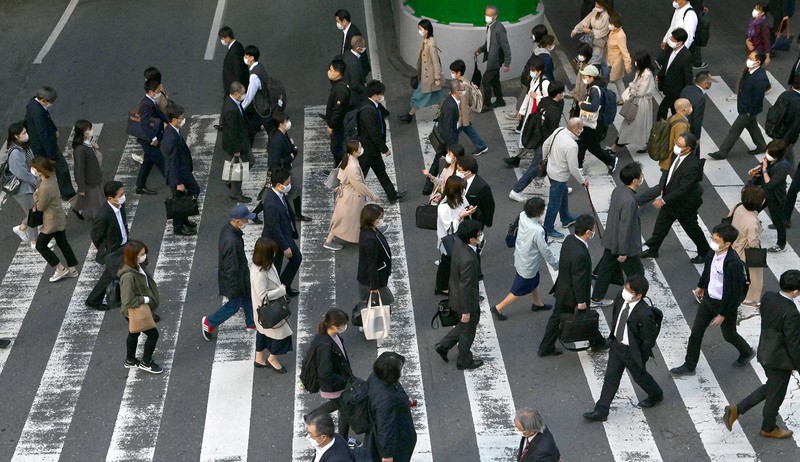 3度目の緊急事態宣言が発令された大阪・梅田を、マスク姿で通勤する人たち=大阪市北区で2021年4月26日午前8時2分、望月亮一撮影