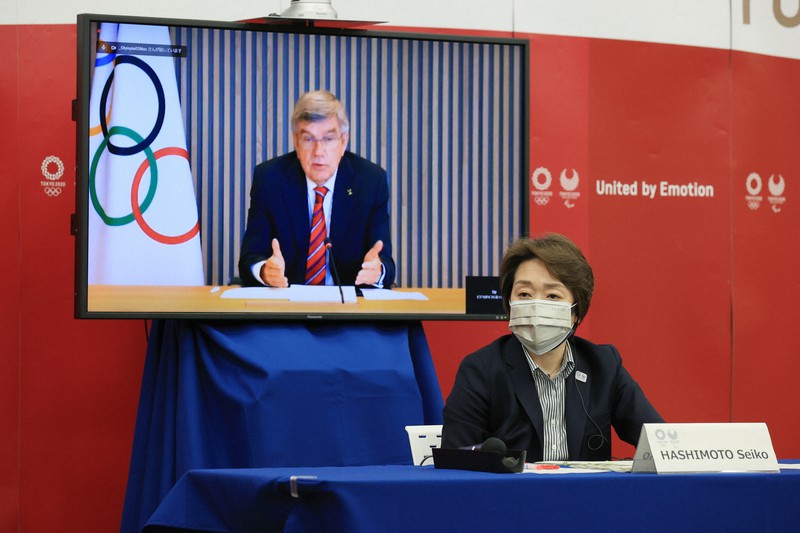 東京オリンピック・パラリンピックに向けた5者協議で国際オリンピック委員会（IOC）のトーマス・バッハ会長（後方モニター）の発言を聞く大会組織委員会の橋本聖子会長＝東京都中央区で2021年4月28日午後6時40分（代表撮影）