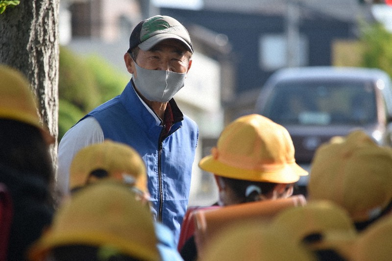 「あいさつ運動」で児童たちの登校を見守る廣瀬裕司さん=三重県名張市の百合が丘小学校前で、行方一男撮影