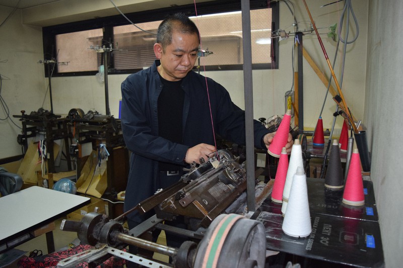 ニット編み機を調整する小高集さん=清水憲司撮影
