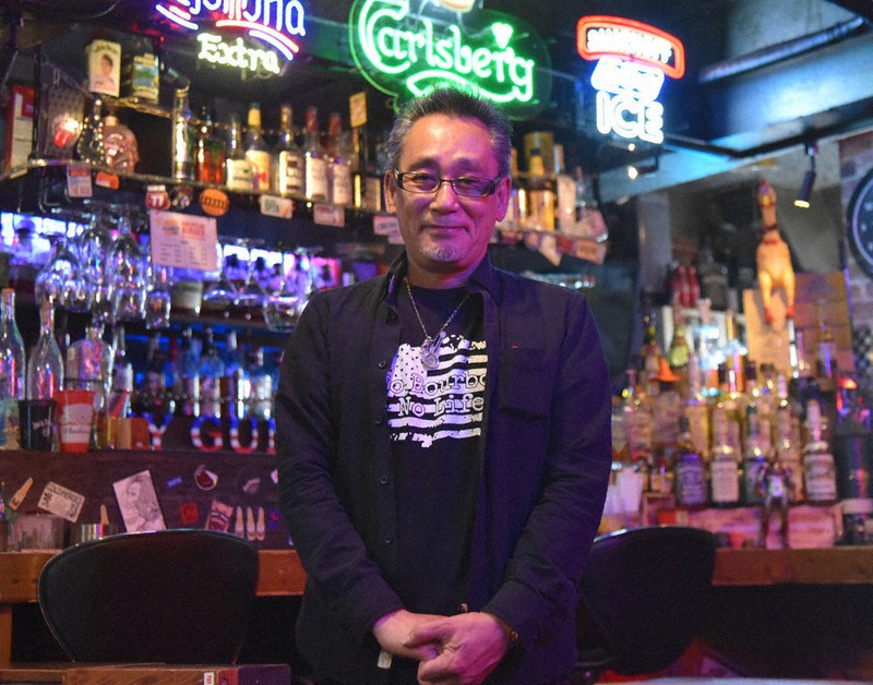 店のカウンターの前に立つ石澤修英さん=埼玉県春日部市中央の「ファニーガンズ」で4月1日