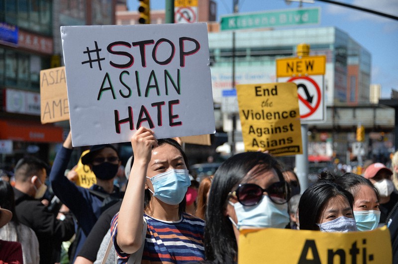 アジア系市民への差別に反対するプラカードを掲げる抗議集会の参加者=米ニューヨークで2021年3月27日、隅俊之撮影