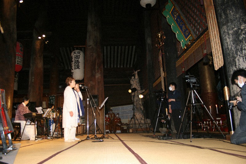 蔵王堂で演奏に合わせて歌を奉納する荒井敦子さん(中央)ら=奈良県吉野町の金峯山寺で2021年4月21日、堀川剛護撮影